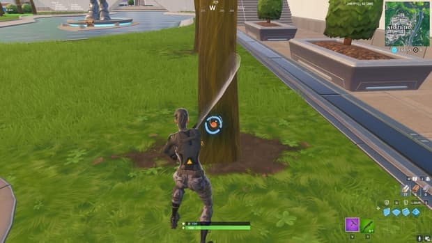 Farming a small tree in Fortnite and hitting the circle to gain more material